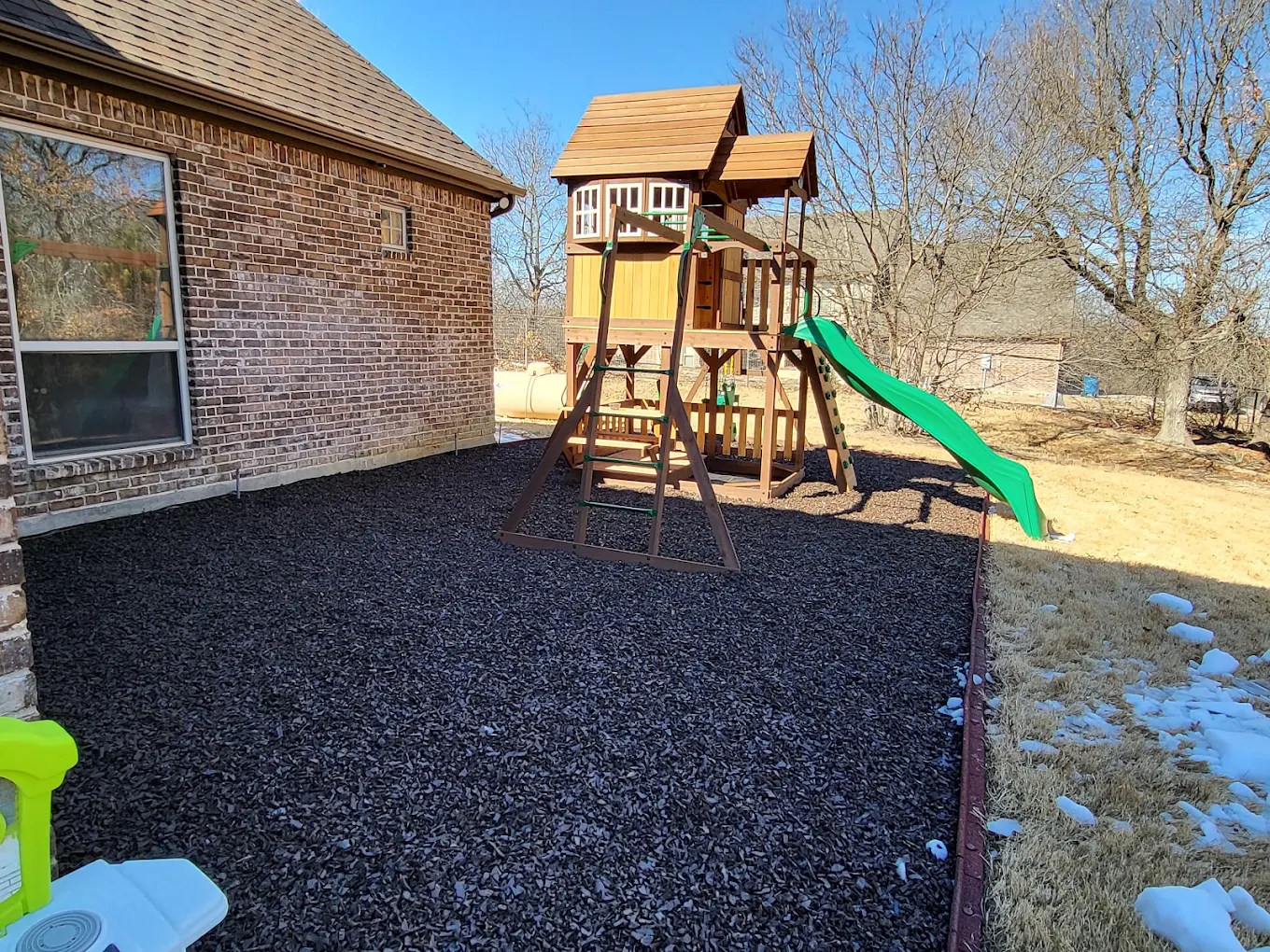 Fresh mulch ground cover around a backyard play area